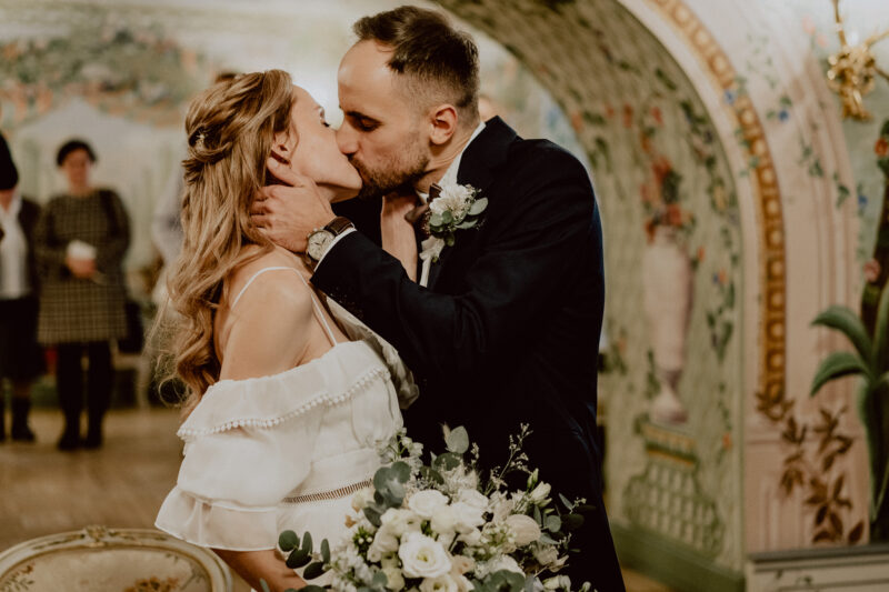 Całująca się młoda para chwilę po zawarciu związku małżeńskiego w USC w Białymstoku