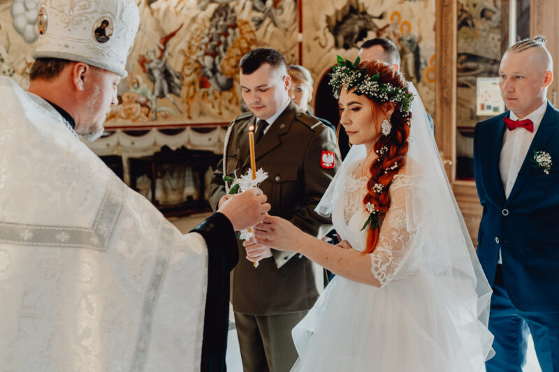 Panna młoda otrzymuje świecę na ślubie prawosławnym