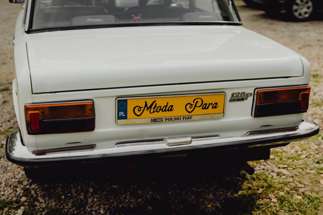 Stary fiat 125p biały z tablicą resjestracyjną "młoda para"
