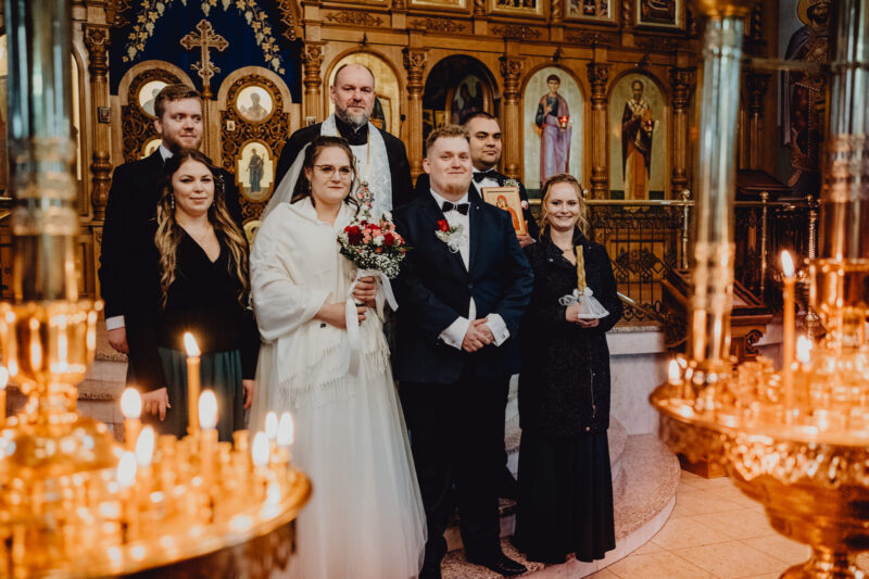 Wspólne zdjęcie pary młodej z księdzem zaraz po ślubie w cerkwii