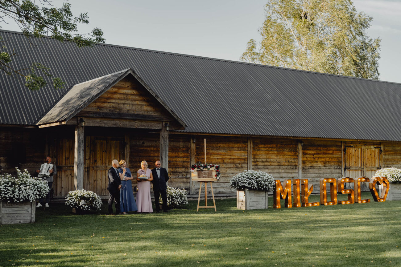 Rodzice czekają na Państwa Młodych przed Stodołą Weselną Chata za Wsią.
