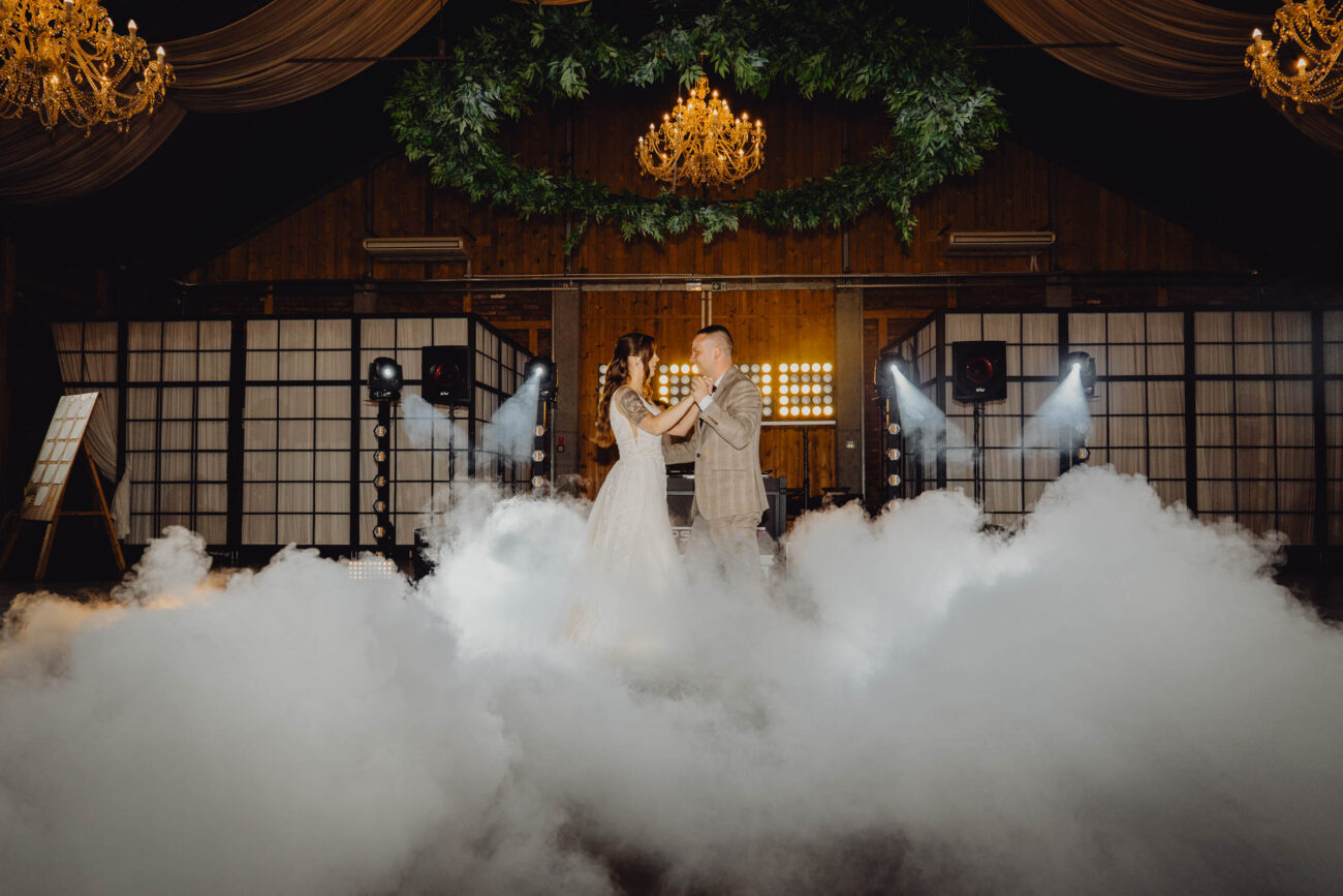 Para Młoda tańczy swój 1 taniec w ogromnej Ekskluzywnej Stodole Weselnej Majątku Howieny. Ciężki dym spowija parkiet.