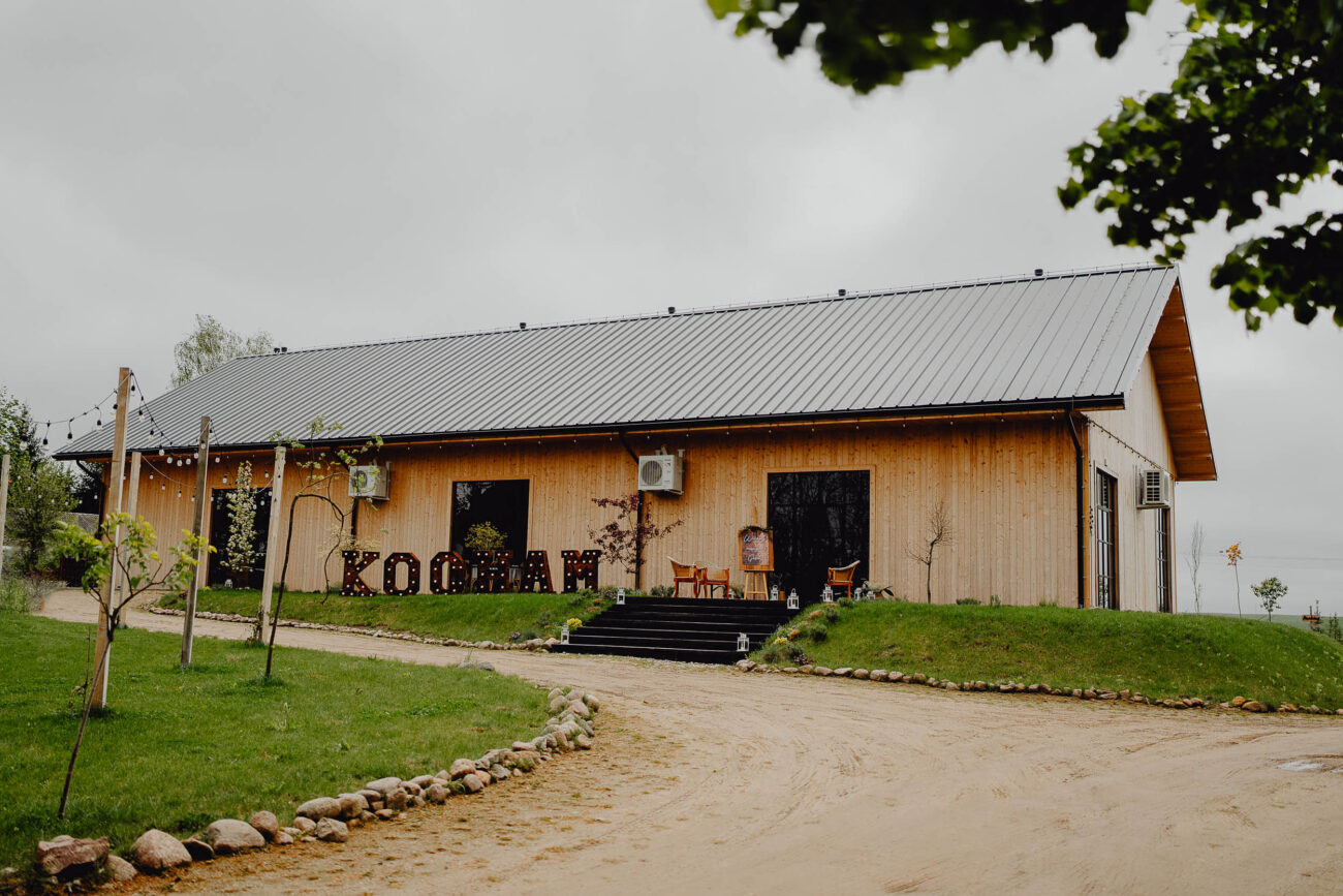 Stodoła Weselna Łąki i Pola zdjęcie z przodu od strony wejścia. Widac schody i piękny drewniany napis "Kocham".