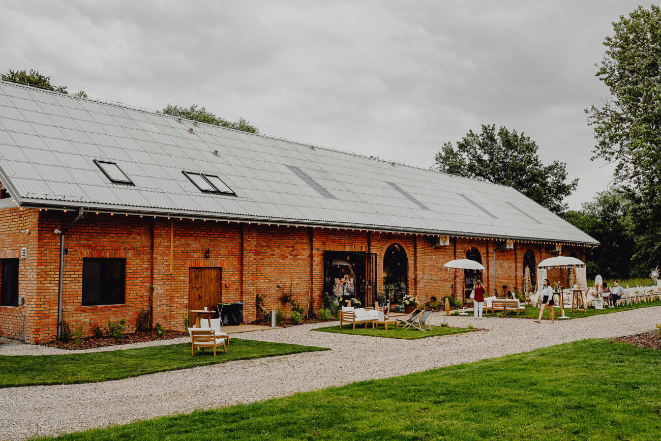 Stodoła Weselna Między Travami zdjęcie z daleka, widać całą stodołę.