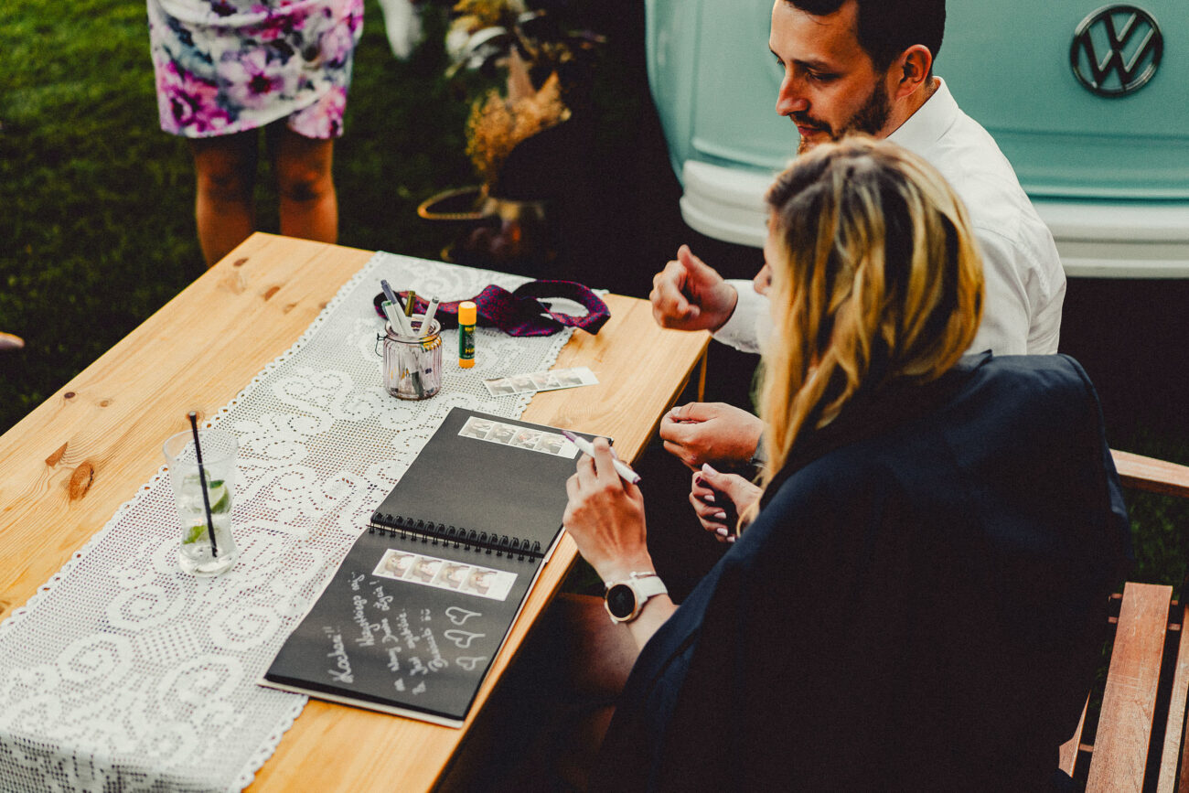 Goście weselni wpisują sie do księgi gości.