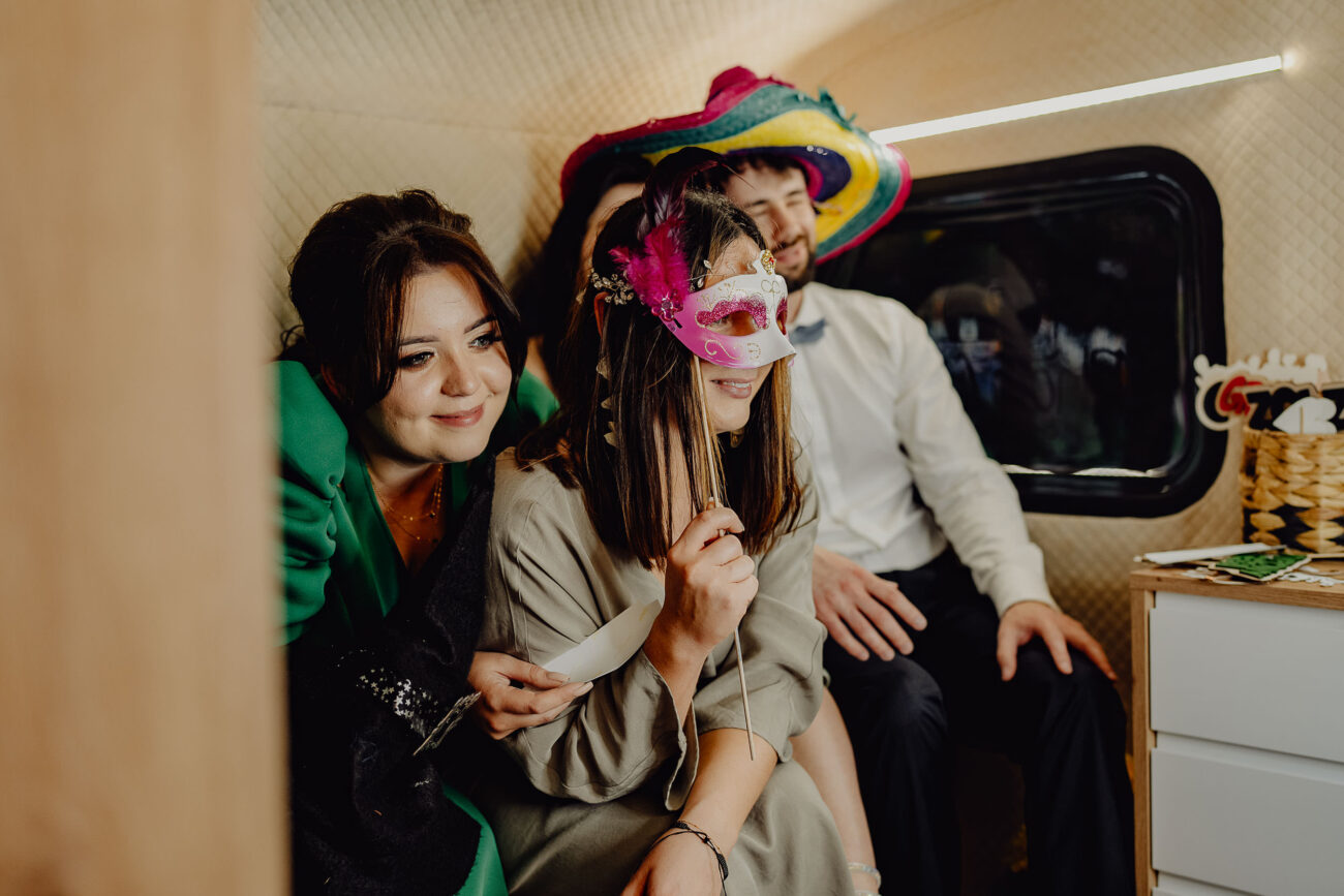 Goście weselni w fotobusie podczas robienia zdjęć pamiątkowych.