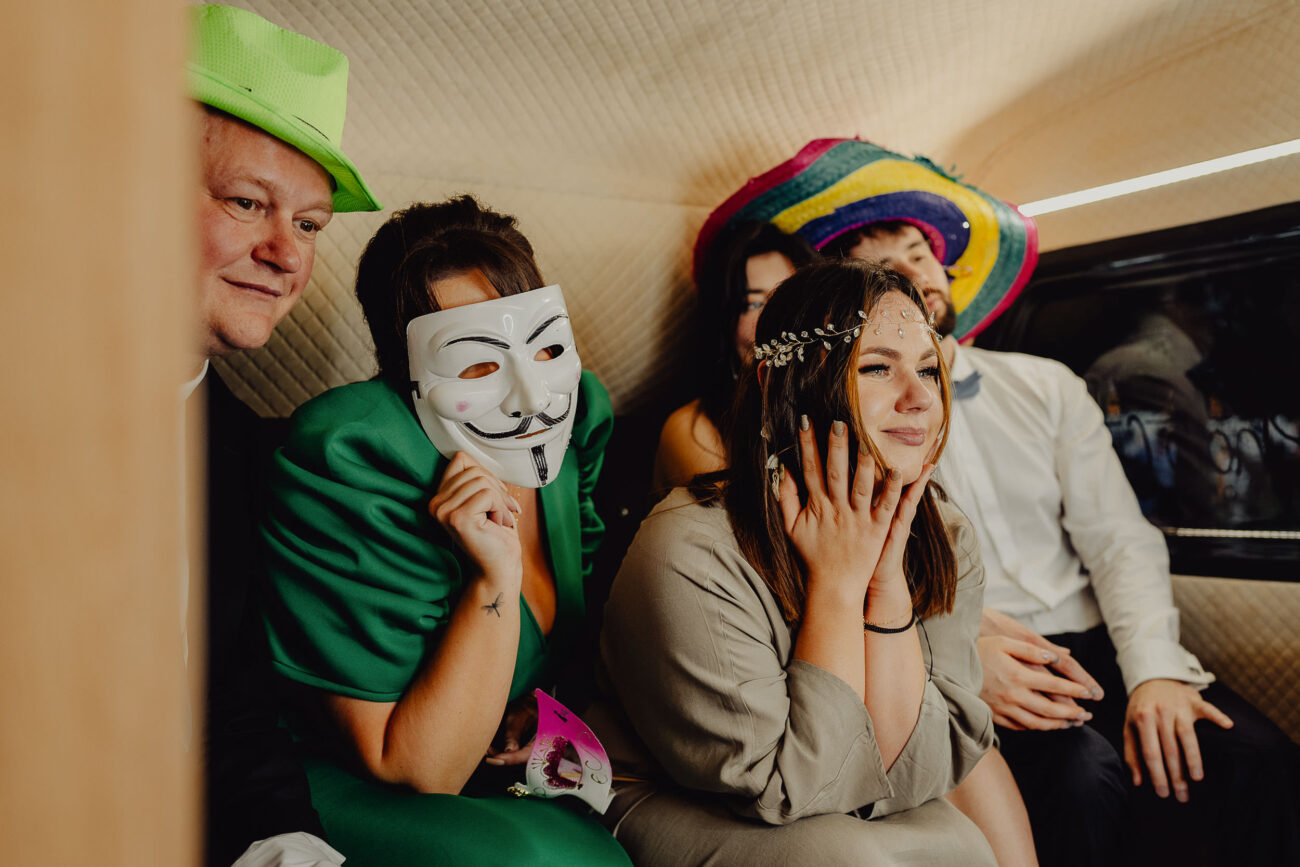 Goście weselni w fotobusie podczas robienia zdjęć pamiątkowych.