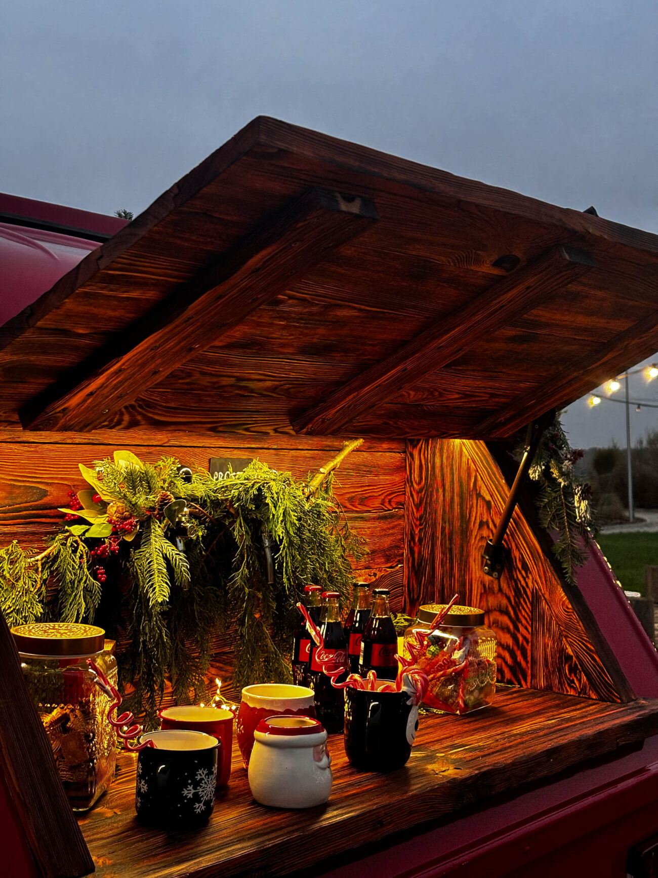 Otwierana półka na Fotoprzyczepie HONOTU gdzie można sobie wlać napoju i posmakować słodkości. Półka znajduje się z boku przyczepy.