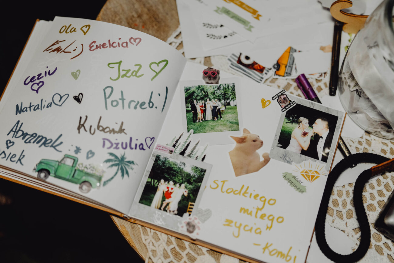 Otwarta księga gości z wpisanymi życzeniami i wklejonym zdjęciem z instaxa.